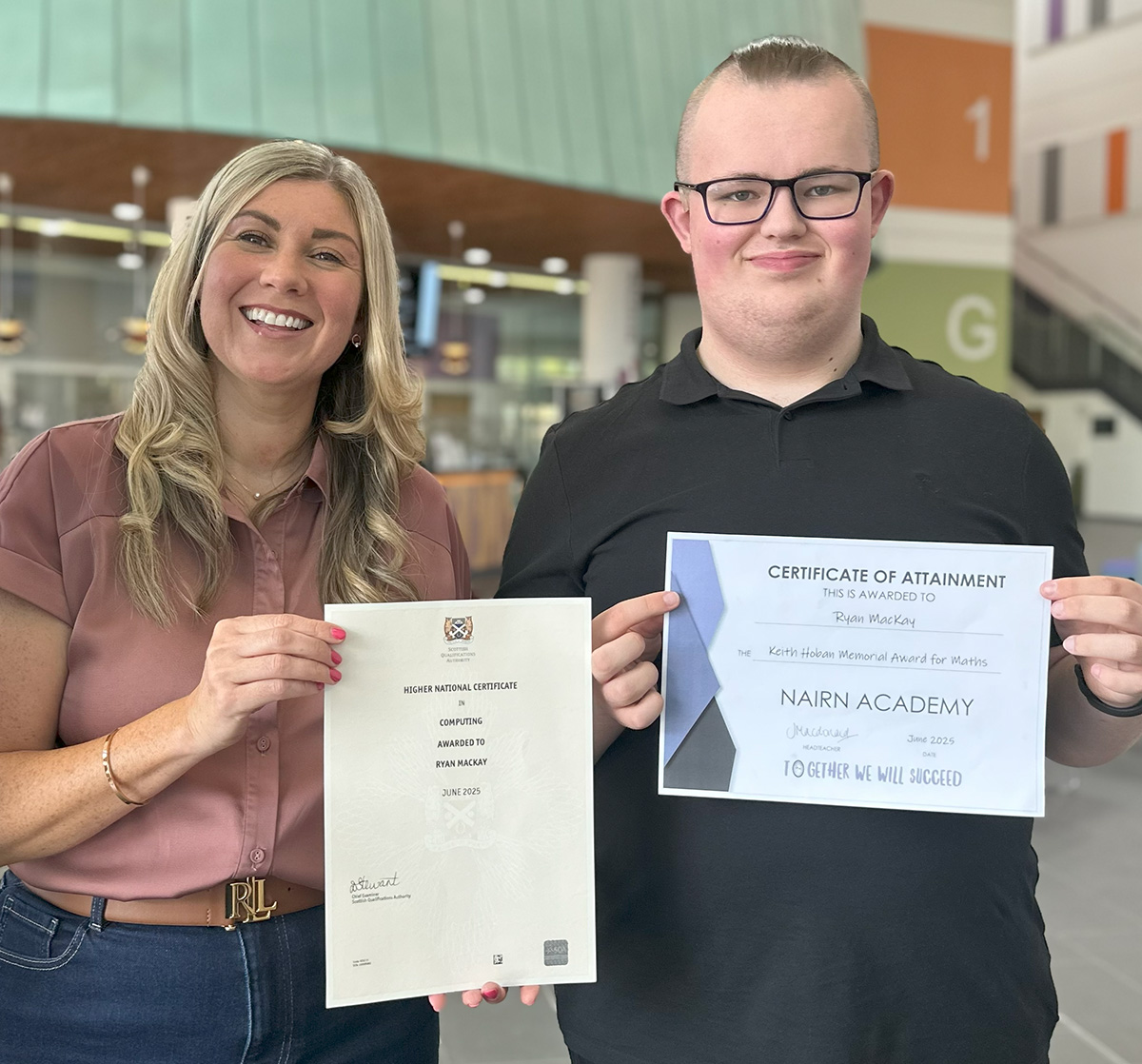 female academic Lindsay Snodgrass and student standing together holding certificates