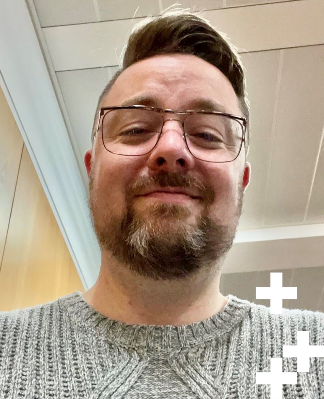 A headshot of Mike McGlynn, Lecturer in Integrative Healthcare at UHI Moray. He has short brown hair, and a short beard. He wears thin black rimmed glasses and is smiling down at the camera.