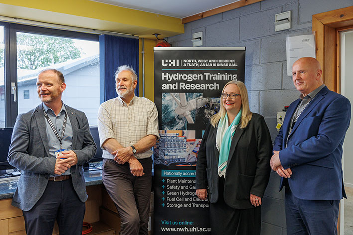 People standing in front of a banner that reads Hydrogen Training and Research