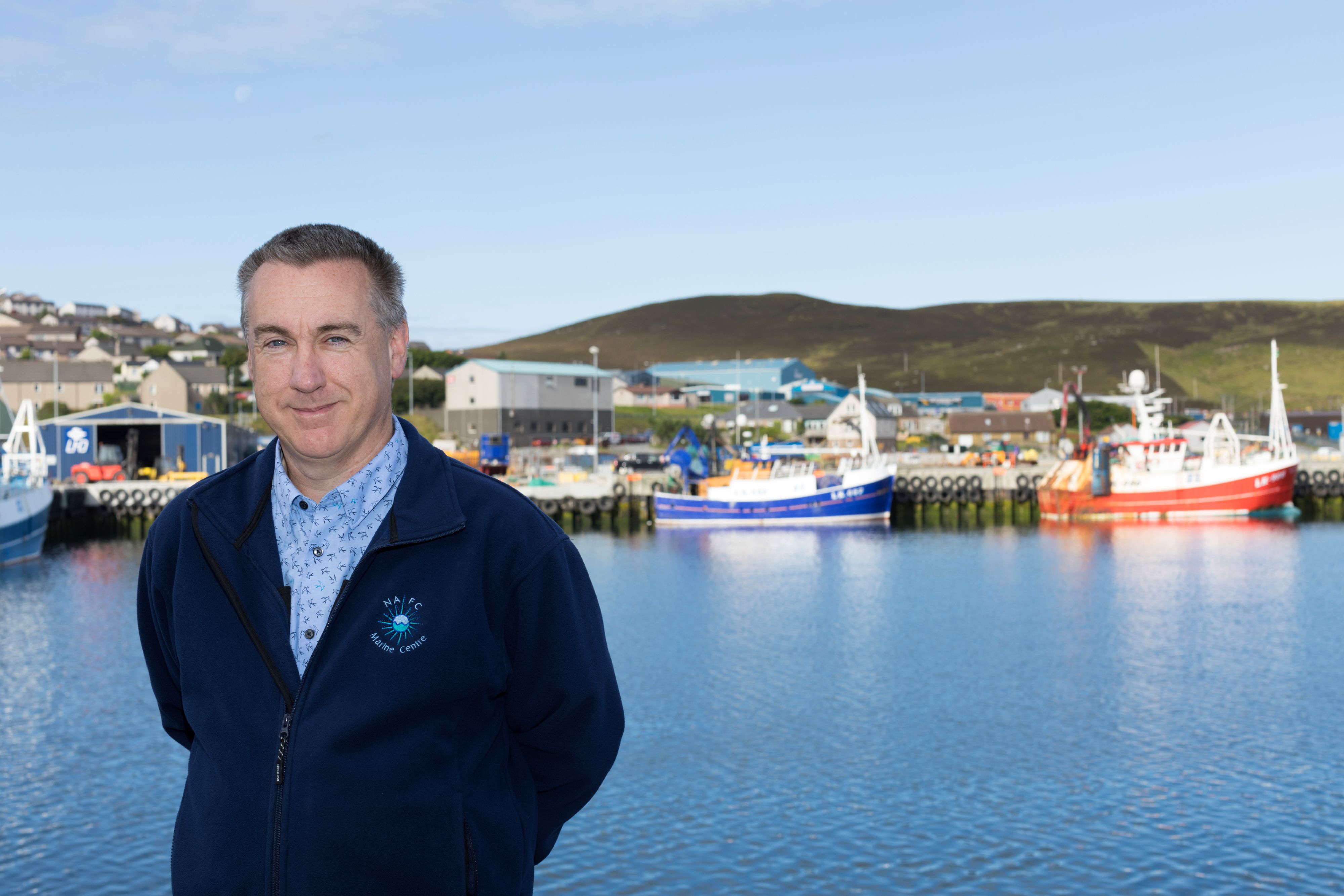 A man stands before a shipping pier