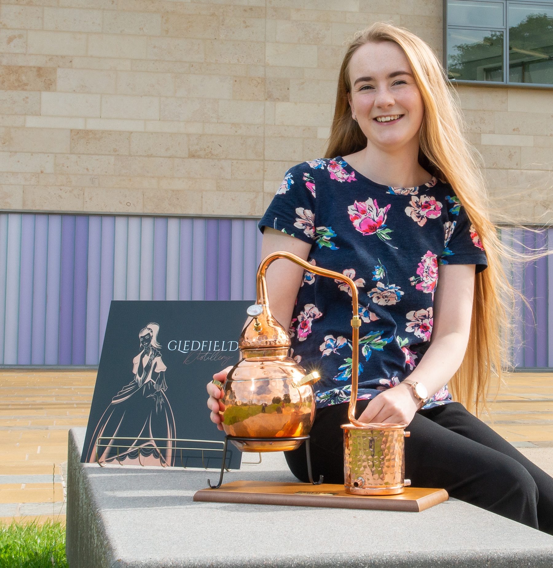 Ciara Bow sitting next to a copper distiller