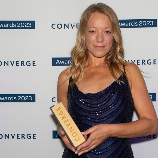 Dr Georgina Robinson holding wooden trophy from Converge