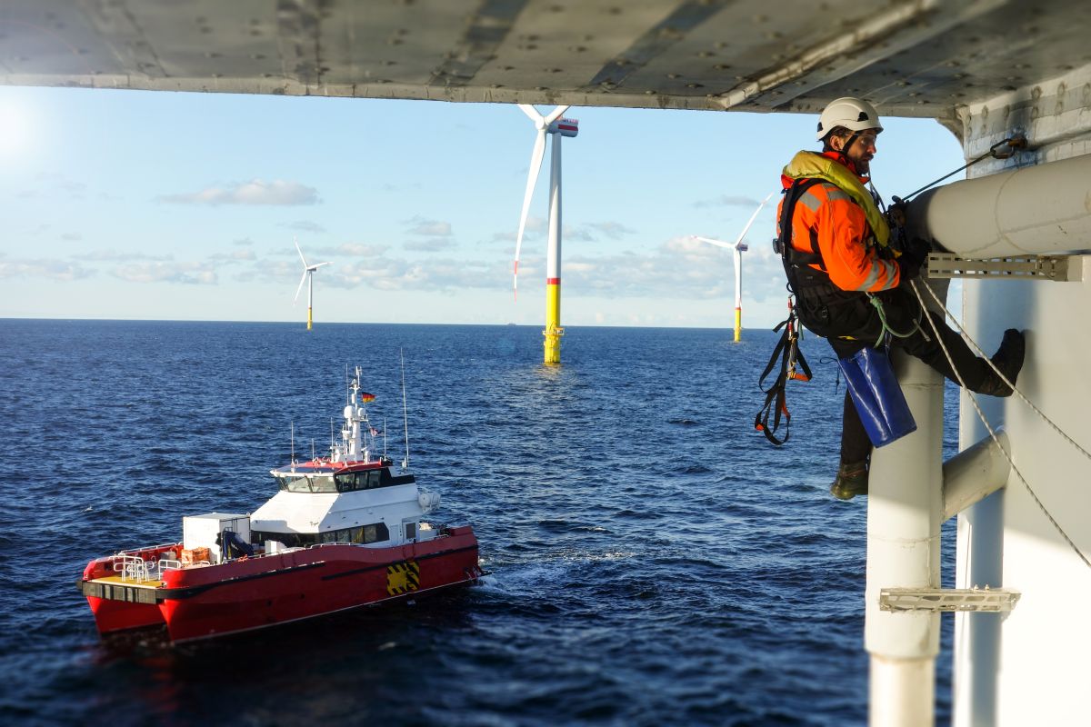 Person doing maintenance on an offshore wind turbine Person doing maintenance on an offshore wind turbine