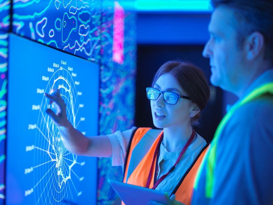 Two people looking at a large digital map