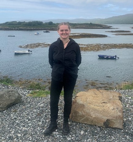 A student standing on the beach