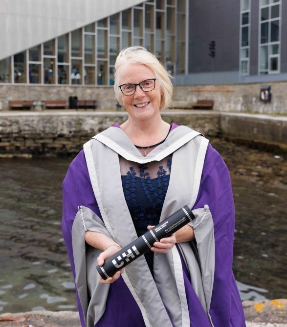 Helen Budge MBE holding UHI scroll 