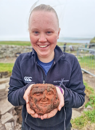 UHI Archaeology Institute student Katie Joss with the Skaill carved head. (Photo: ORCA)