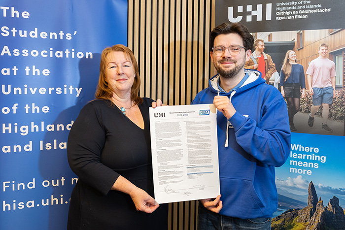 Two people holding a signed agreement Two people holding a signed agreement