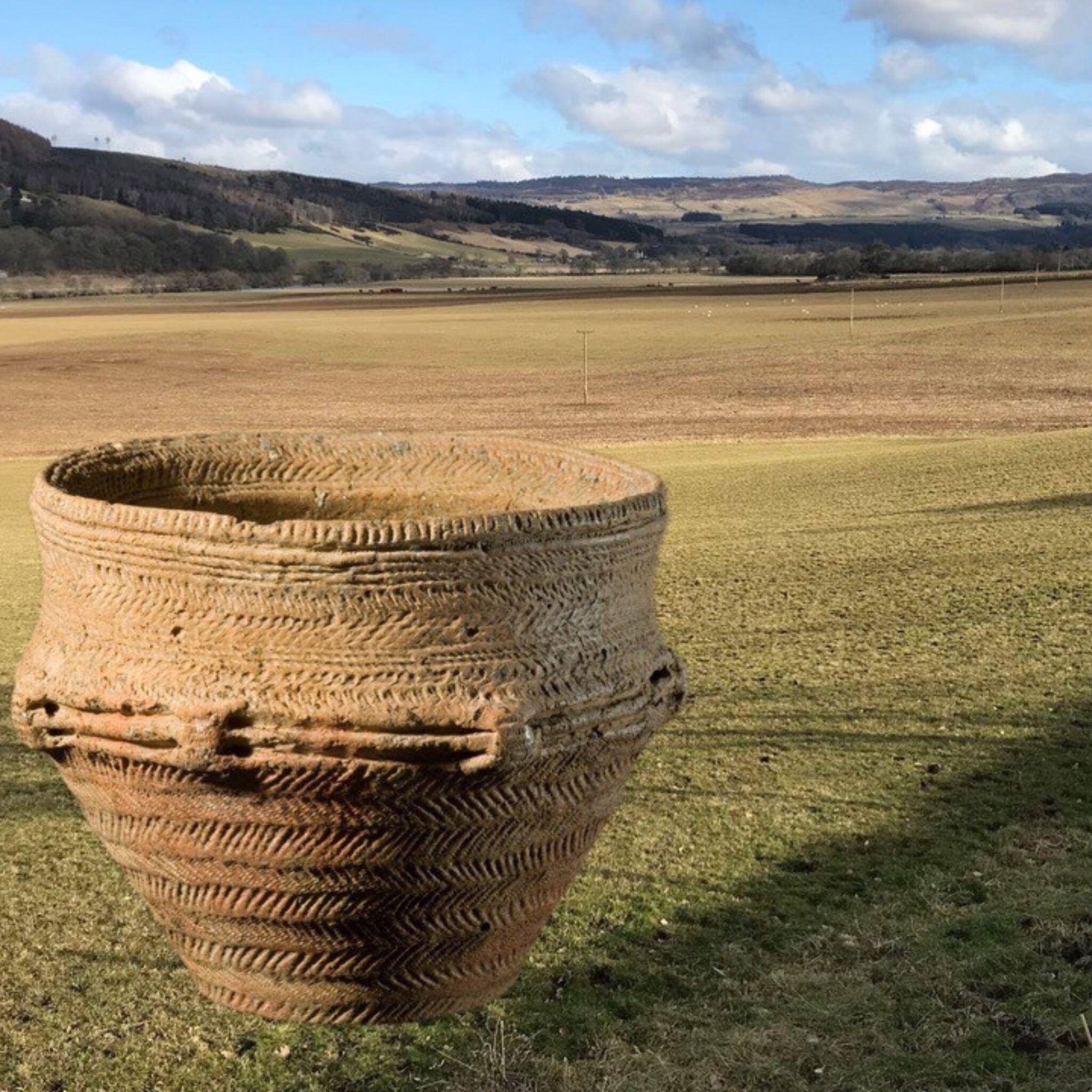 A photo montage of a funerary urn and landscape