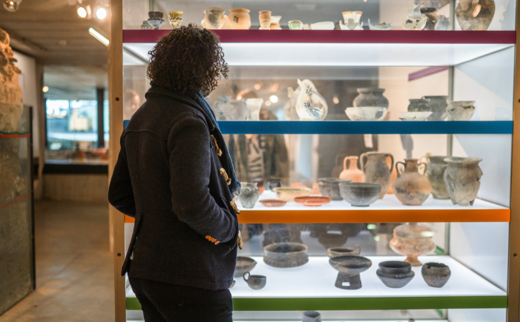 Woman walking around a pottery exhibition