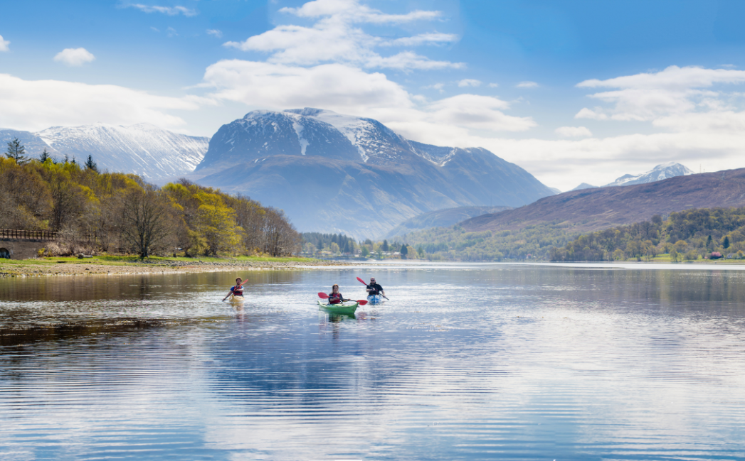 People kayaking with mountains in the background